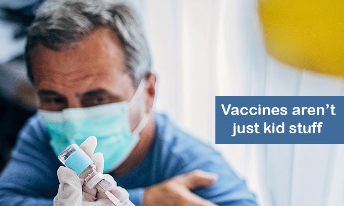 grey haired man wearing face mask pulls up his shirt sleeve preparing for a vaccine shot